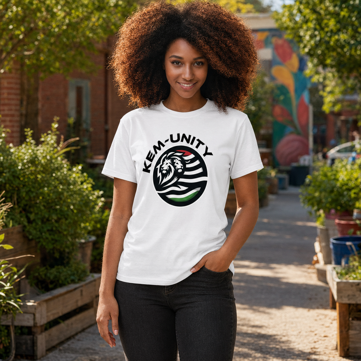 Woman wearing the white Kem-Unity Cookie Waas Djed T-shirt in a community garden
